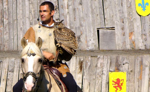 Equestrian falconry show with a great horned owl on the glove of Jacques-Olivier Travers, its falconer.
