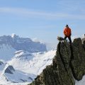 Jacques-Olivier accompagné de son oiseau au sommet d'une montagne.